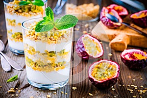 Yogurt parfait with granola, peach sauce and passion fruit with mint