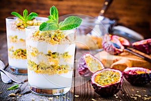 Yogurt parfait with granola, peach sauce and passion fruit with mint