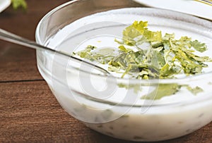 yogurt soup with herbs in a plate on a wooden table.spas .