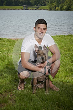 Yoing man poses with his dog in outdoor park