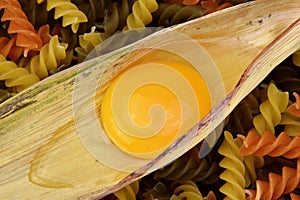 Yolk and albumen. Egg in a corn leaf and pasta.