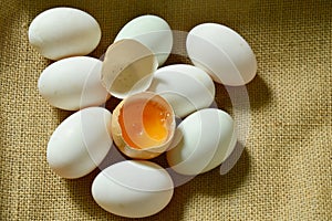Yolk in crack brown egg on sackcloth