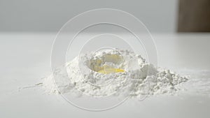 Yolk falling into flour in slow motion