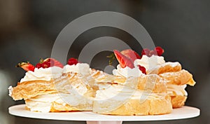 Yolk wreaths with cream and strawberries, closeup.