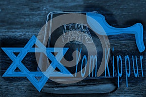 Yom Kippur Day of Atonement, concept. In the foreground: Magen David Jewish star, title Yom Kippur and Shofar Ramâ€™s Horn