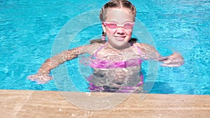 Yong girl wearing water glasses and diving in the swimming pool. Slow motion