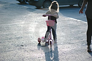 Yong kid girl ride on street with child scooter