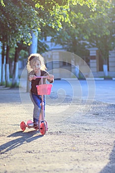 Yong kid girl ride on street with child scooter