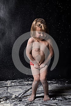 Yong kids playing with flour. Black textured background