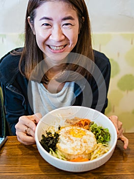 Yong lady smiling with Bibimbap