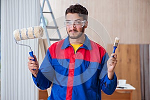 The yooung repairman carpenter working with paint painting