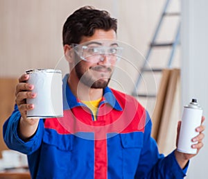 Yooung repairman carpenter working with paint painting