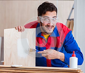 Yooung repairman carpenter working with paint painting