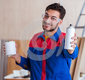 Yooung repairman carpenter working with paint painting