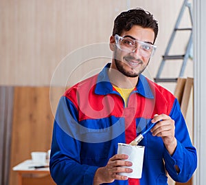 Yooung repairman carpenter working with paint painting