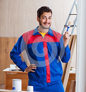 Yooung repairman carpenter working with paint painting