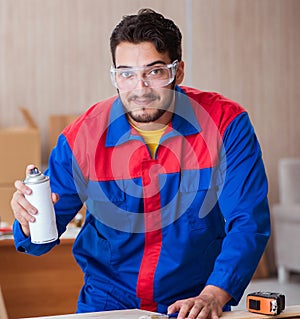 Yooung repairman carpenter working with paint painting