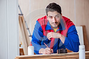 The yooung repairman carpenter working with paint painting