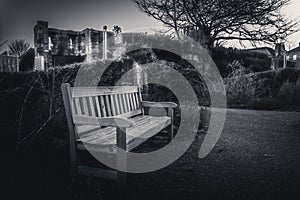 YORK, ENGLAND, DECEMBER 12, 2018: Wooden bench in an old park full of dry leaves. Concept of tranquility and peaceful moment