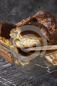Yorkshire pudding in a glass dish with a portion cut on a spatula. British food concept