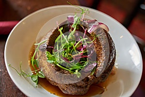 Yorkshire pudding with topping of fresh leaves