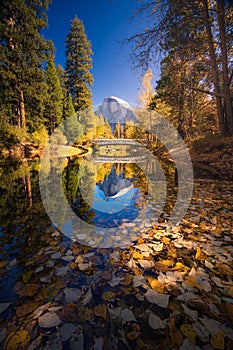 Yosemite Valley river with reflection of Half-Dome and autumn trees