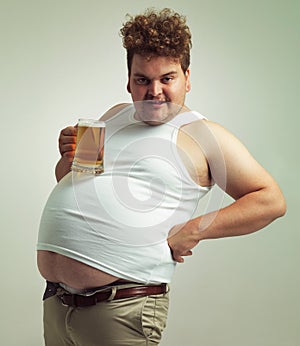 Are you admiring my beer table. an overweight man looking content while balancing his beer on his stomach.