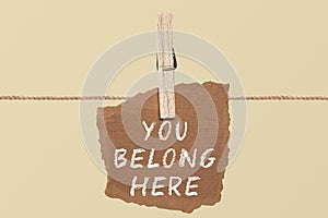 You belong here    A paper on the pegs. And this is the word written