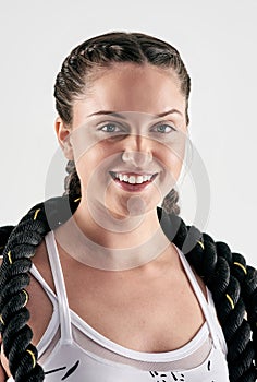 You can be strong, powerful and beautiful all in one. Studio portrait of a sporty young woman posing with battle ropes