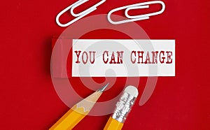 YOU CAN CHANGE message written on torn red paper with pencils and clips, business
