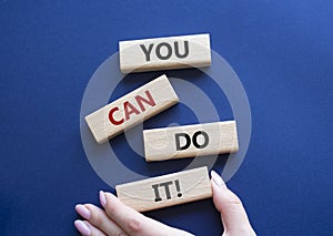 You can do it symbol. Concept words You can do it on wooden blocks. Beautiful deep blue background. Businessman hand. Business and