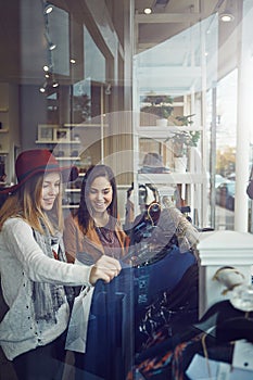 You can never have too much clothing. two best friends out shopping in a clothing store.