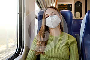 You can sleep peacefully. Relaxed beautiful woman with medical face mask sleeping sitting in the train. Train passenger traveling