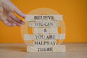 You can symbol. Concept words Believe you can and you are halfway there on brick blocks on a beautiful wooden table green