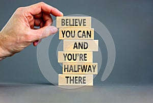 You can symbol. Concept words Believe you can and you are halfway there on wooden blocks on a beautiful grey table grey background