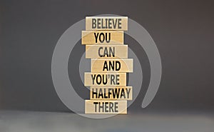 You can symbol. Concept words Believe you can and you are halfway there on wooden blocks on a beautiful grey table grey background