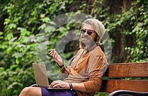 You can work anywhere. Hipster inspired work in park. Agile business. Bearded guy sit on bench in park nature background