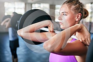 You cant go wrong with strong. a young woman working out with weights at the gym.