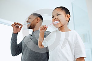 You cant start the today with yesterdays breath. an adorable little girl and her father brushing their teeth together at