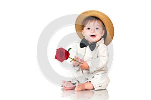 Smiling one old year boy in retro, bow-tie hat and with red rose sitting on white background.