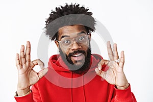You doing great. Satisfied and delighted outgoing african american bearded man in glasses with afro hairstyle wearing