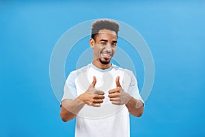 You doing great, support you. Satisfied creative and stylish young african american man with beard winking joyfully
