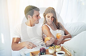 Are you enjoying your breakfast, my love. a loving young couple enjoying breakfast in bed.
