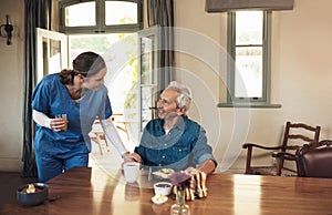 Are you enjoying your meal. a young nurse checking up on a senior man during breakfast at a nursing home.