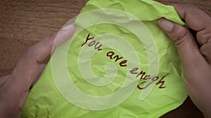 You are enough: Top-View of Hands Opening Crushed Paper Message of \