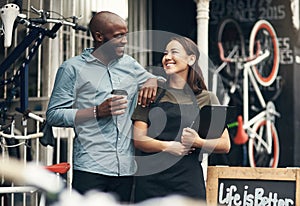 You have everything under control here, huh. Shot of two young business owners standing outside their bicycle shop