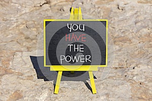 You have the power symbol. Concept word You have the power on beautiful black chalk blackboard. Beautiful red stone background.