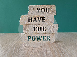 You have the power symbol. Concept word You have the power on brick block. Beautiful green background, wooden table. Business