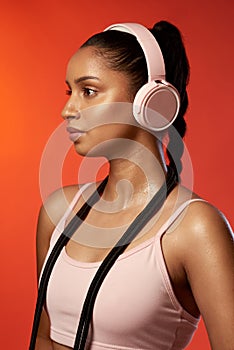 You have to be prepared to work for it. Studio shot of a sporty young woman wearing headphones and posing with a