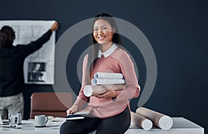 You have to outwork everyone to be the best. Portrait of a female architect carrying blueprints and building plans in an